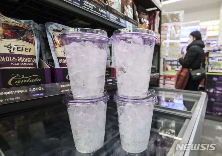 [서울=뉴시스] 김근수 기자 = 지난달 14일 서울 한 편의점에서 한 시민이 얼음컵을 구매하고 있다. 국내 3사 편의점 (CU, GS25, 세븐일레븐)이 모든 얼음컵 제품 가격을 100원 인상한다고 밝혔다. 2023.02.14. ks@newsis.com
