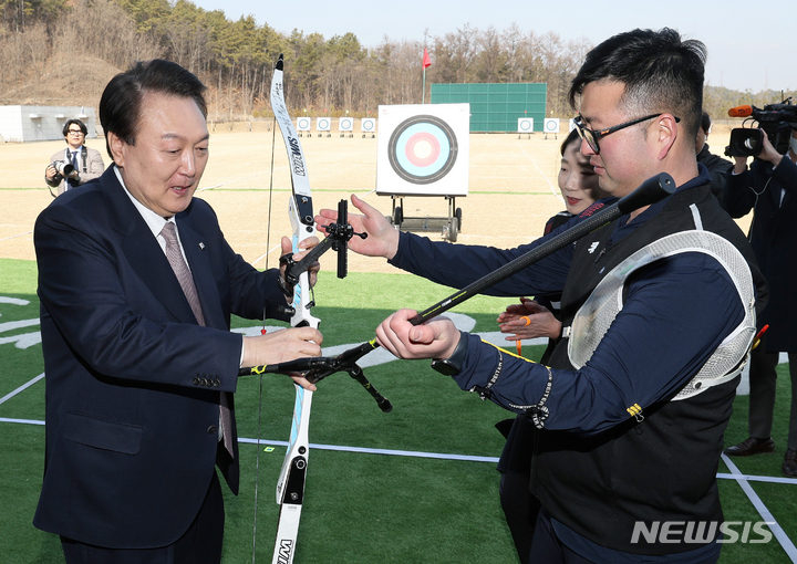 [진천=뉴시스] 홍효식 기자 = 윤석열 대통령이 14일 충북 진천선수촌에서 열린 2023 대한민국 체육비전 보고회를 마친 뒤 양궁장을 방문해 김우진, 최미선 선수에게 도쿄올림픽 친필 사인이 담긴 활을 선물받고 있다. (대통령실통신사진기자단) 2023.02.14. yesphoto@newsis.com