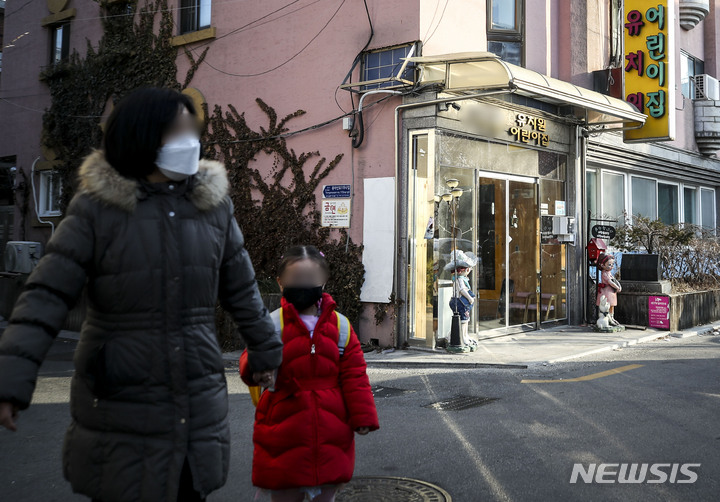 [서울=뉴시스] 저출생에 따른 학령인구 감소로 사립유치원 폐원이 늘어나고 있다. 사진은 지난 2월15일 오전 서울시내의 한 폐원한 사립유치원 앞에서 한 어린이가  학부모 손을 잡고 이동하고 있다. (사진=뉴시스DB). 2023.04.10. photo@newsis.com