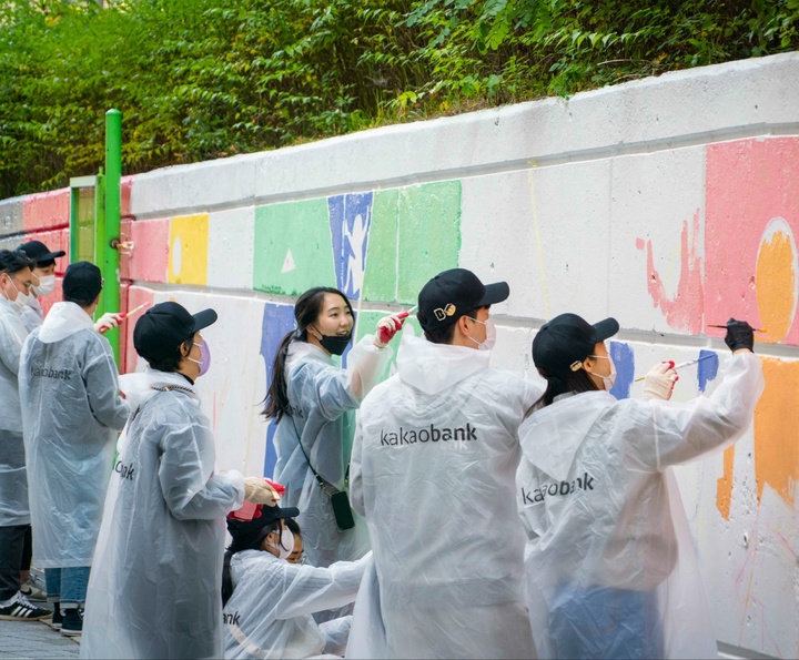 카카오뱅크 직원들이 경기 성남시 중원구에 있는 은행중학교에서 벽화 그리기 봉사활동을 하고 있다. *재판매 및 DB 금지