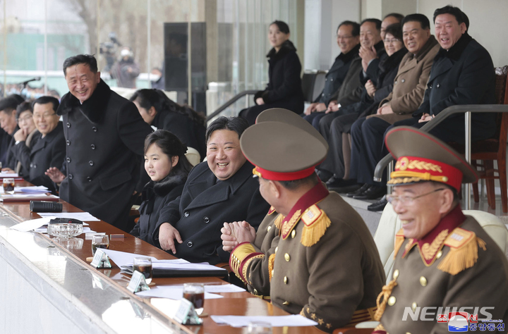 [평양=AP/뉴시스] 북한 조선중앙통신이 제공한 사진에 김정은(가운데) 북한 국무위원장이 17일 딸 주애양과 함께 장소가 알려지지 않은 곳에서 열린 광명성절 기념 체육 경기를 관람하면서 환히 웃고 있다. 김여정 부부장은 뒷줄 왼쪽 구석에 앉았다. 2023.02.18.