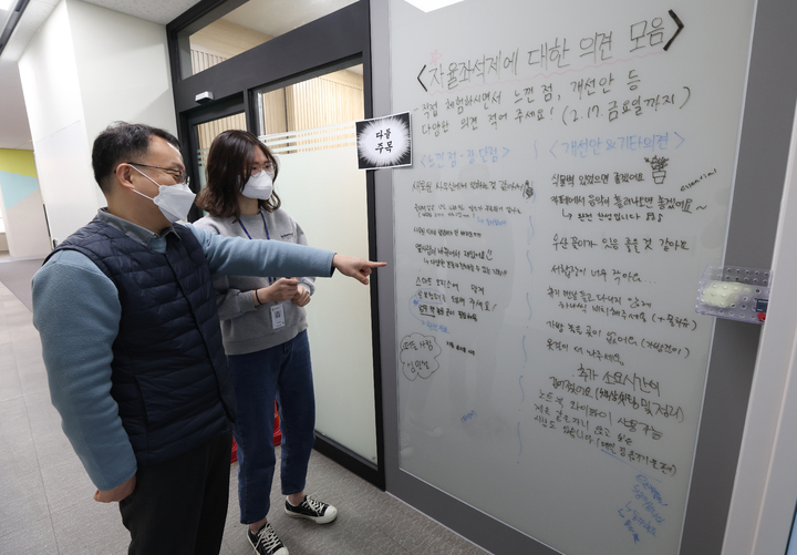 [세종=뉴시스] 21일 정부세종청사 처음으로 자율좌석형 사무공간이 조성된 교육부 디지털교육기획관 사무실 입구에 설치된 의견 게시판을 직원들이 읽어보고 있다. (사진=교육부 제공). 2023.02.21. photo@newsis.com *재판매 및 DB 금지