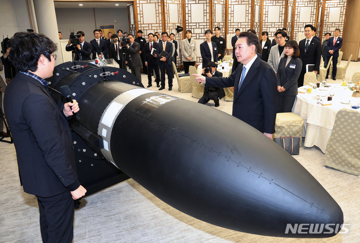 [서울=뉴시스] 전신 기자 = 윤석열 대통령이 21일 서울 용산 대통령실 청사에서 열린 '꿈과 도전의 뉴스페이스 시대, 우주경제 개척자와의 대화'에 앞서 소형 우주 발사체를 살펴보고 있다. (대통령실통신사진기자단) 2023.02.21. photo1006@newsis.com