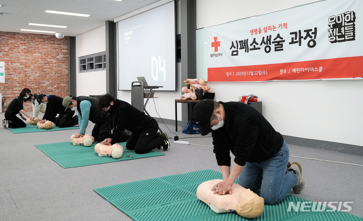 [수원=뉴시스] 우아한청년들 관계자들이 22일 이륜차 교육전문시설 배민라이더스쿨에서 심폐소생술 교육을 받고 있다. (사진=적십자 제공)
