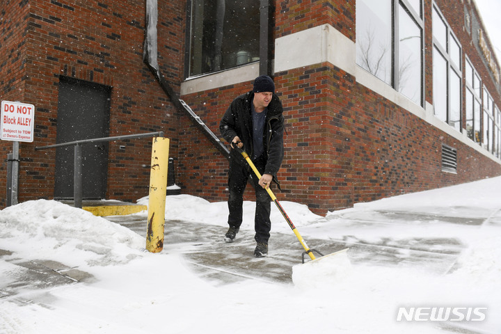 [수폴스=AP/뉴시스] 21일(현지시간) 데이비드 스미스가 사우스다코타 수폴스에서 눈 폭풍을 앞두고 첫 눈이 내린 보도 위의 눈을 치우고 있다. 2023.02.22.