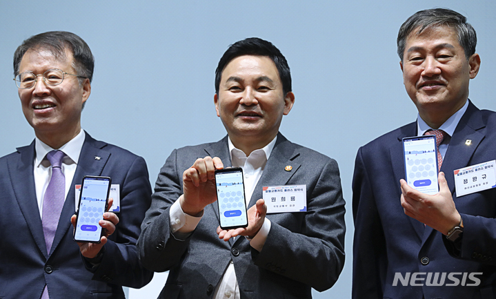 [서울=뉴시스] 최진석 기자 = 원희룡 국토교통부 장관이 22일 서울 중구 포스트타워 대회의실에서 열린 '알뜰교통카드 플러스 협약식'에서 알뜰교통카드 앱을 보이며 기념촬영을 하고 있다. 왼쪽부터 권용복 한국교통안전공단 이사장, 원 장관, 정완규 여신금융협회 회장. 2023.02.22. myjs@newsis.com
