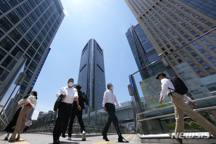 [도쿄=AP/뉴시스]일본 대기업들의 올해 여름 상여금(보너스)이 직원 1인당 평균 98만3112엔(약 850만원)으로 전년 보다 4% 가량 증가해 조사를 시작한 1981년 이후 가장 높다고 현지 공영 NHK가 12일 보도했다. 2022년 6월13일 도쿄의 고층 빌딩을 배경으로 행인들이 지나가고 있다. 2024.07.12.