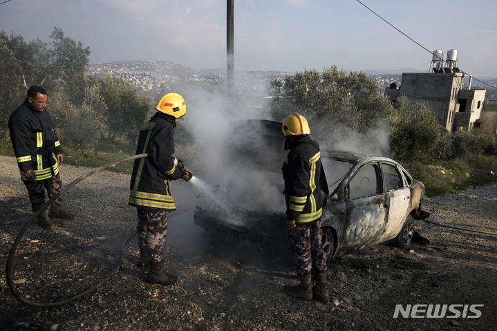   [ 나블루스(요르단강 서안)=AP/뉴시스 ]  나블루스 부근의 부린 시내에서 난동을 부린 이스라엘 정착촌민들이 25일 일으킨 화재를 팔레스타인 소방대원들이 진화하고 있다.    
