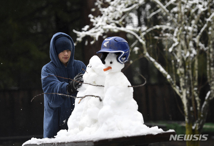 [캘리포니아=AP/뉴시스] 눈폭풍이 서부 해안가를 강타한 가운데, 제이든 샤브리(15)가 24일(현지시간) 캘리포니아 볼더 크릭에서 눈사람을 만들며 놀고 있다. 미 전역을 강타한 강력한 겨울 폭풍으로 산타크루즈 산맥을 잇는 17번 고속도로가 폐쇄됐다. 2023.02.27.