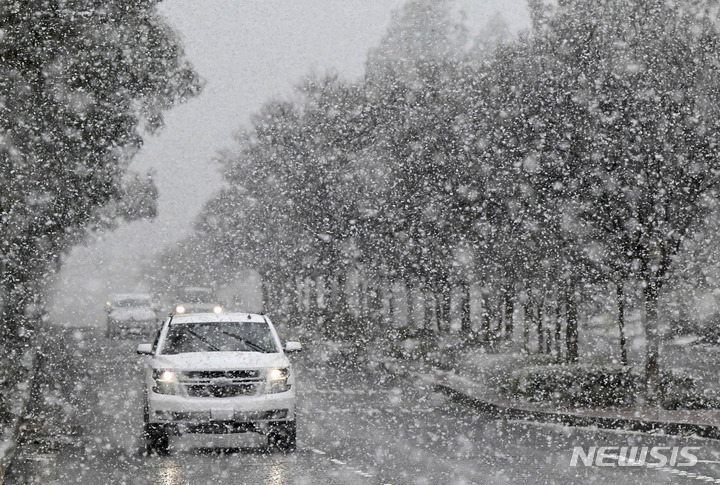 [캘리포니아=AP/뉴시스] 25일(현지시간) 캘리포니아 란초 쿠카몽가에서 약 1,500피트의 눈이 내리고 있는 가운데 한 차량이 윌슨 거리를 지나고 있다. 2023.02.27.