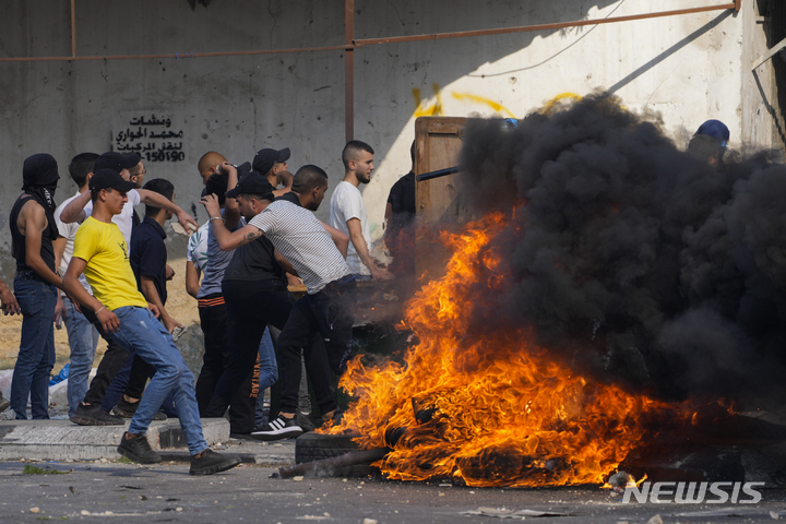 [ 나블루스(요르단강 서안)=AP/뉴시스 ]  26일 발생한 이스라엘 정착촌민의 공격으로 집과 차량이 불탄 뒤 팔레스타인 시위대가 이에 대해 항의하고 있다.    