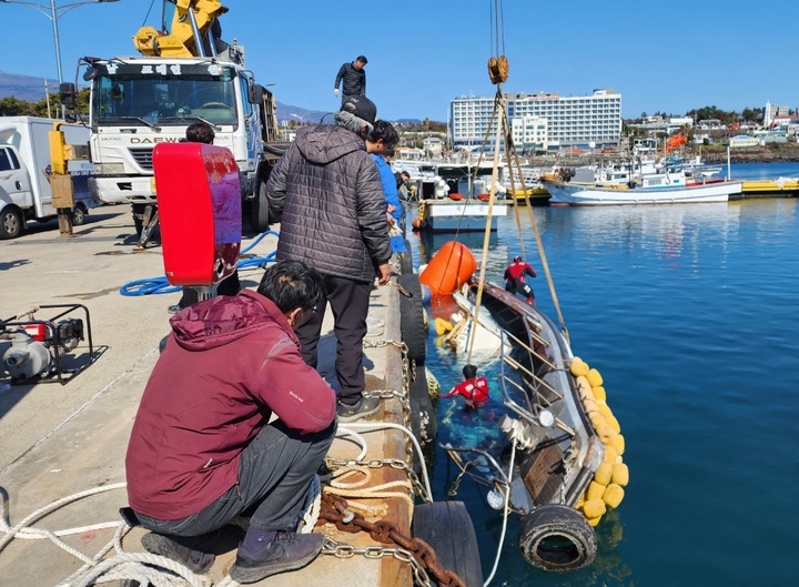 [서귀포=뉴시스] 서귀포해경 관계자들이 제주 서귀포시 남원읍 지귀도 인근 해상에서 좌초된 어선을 육상으로 인양하고 있는 모습. (사진=제주 서귀포해양경찰서 제공) *재판매 및 DB 금지