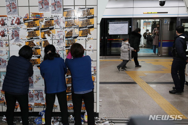 [서울=뉴시스] 백동현 기자 = 서울교통공사 청소노동자들이 27일 오전 서울 용산구 삼각지역 승강장에서 전국장애인차별철폐연대(전장연)의 불법 전단물을 제거하고 있다. 2023.02.27. livertrent@newsis.com
