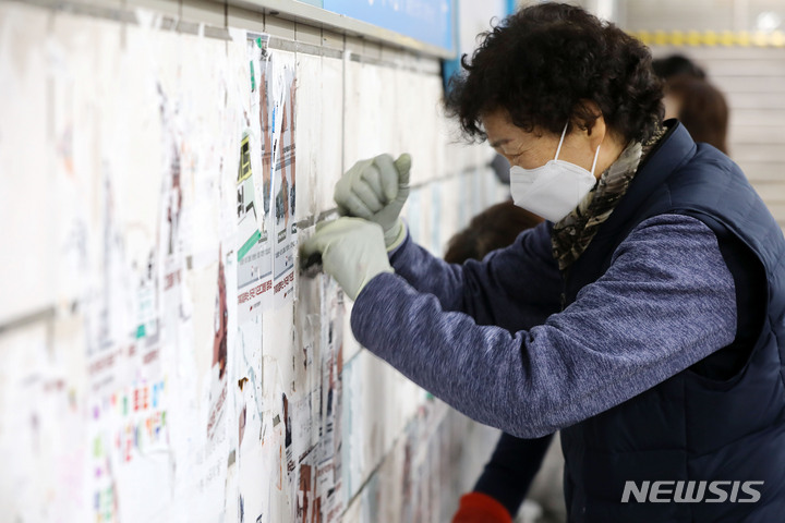 [서울=뉴시스] 백동현 기자 = 서울교통공사 청소노동자들이 27일 오전 서울 용산구 삼각지역 승강장에서 전국장애인차별철폐연대(전장연)의 불법 전단물을 제거하고 있다. 2023.02.27. livertrent@newsis.com