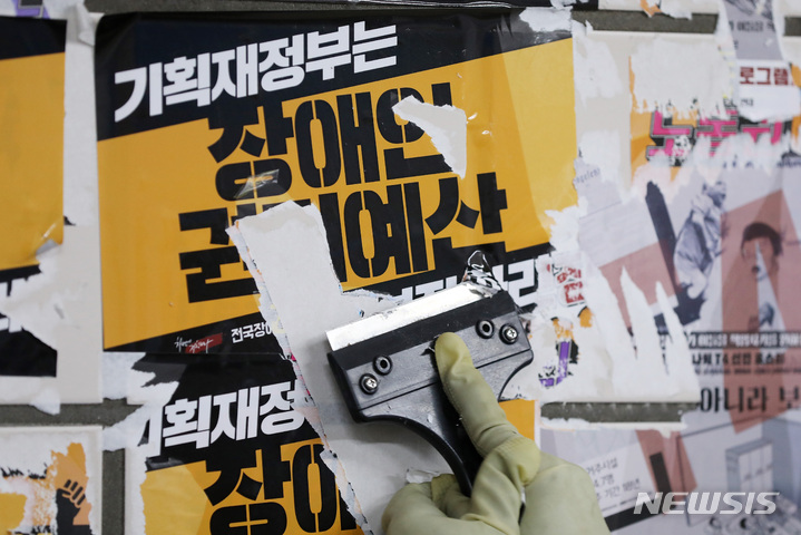 [서울=뉴시스] 백동현 기자 = 서울교통공사 청소노동자들이 27일 오전 서울 용산구 삼각지역 승강장에서 전국장애인차별철폐연대(전장연)의 불법 전단물을 제거하고 있다. 2023.02.27. livertrent@newsis.com