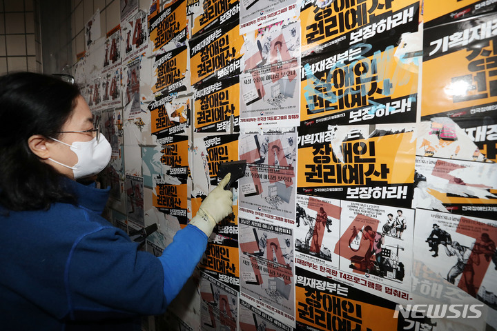 [서울=뉴시스] 백동현 기자 = 서울교통공사 청소노동자들이 27일 오전 서울 용산구 삼각지역 승강장에서 전국장애인차별철폐연대(전장연)의 불법 전단물을 제거하고 있다. 2023.02.27. livertrent@newsis.com