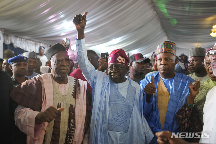[아부자( 나이지리아) =AP/뉴시스] 나이지리아 대선에서 당선된 집권 여당 범진보의회당(APC) 볼라 티누부 후보가 3월 1일 선관위의 당선 발표뒤 지지자들에게 손을 들어 보이고 있다.&nbsp; 하지만 야당은 투표조작이라며 여러 지역에서 재투표를 요구하고 있다.&nbsp;&nbsp; 