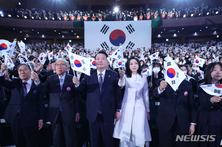 [서울=뉴시스] 홍효식 기자 = 윤석열 대통령과 김건희 여사가 1일 서울 중구 유관순 기념관에서 열린 제104주년 3.1절 기념식에서 만세삼창을 한 뒤 태극기를 흔들고 있다. (대통령실통신사진기자단) 2023.03.01. yesphoto@newsis.com