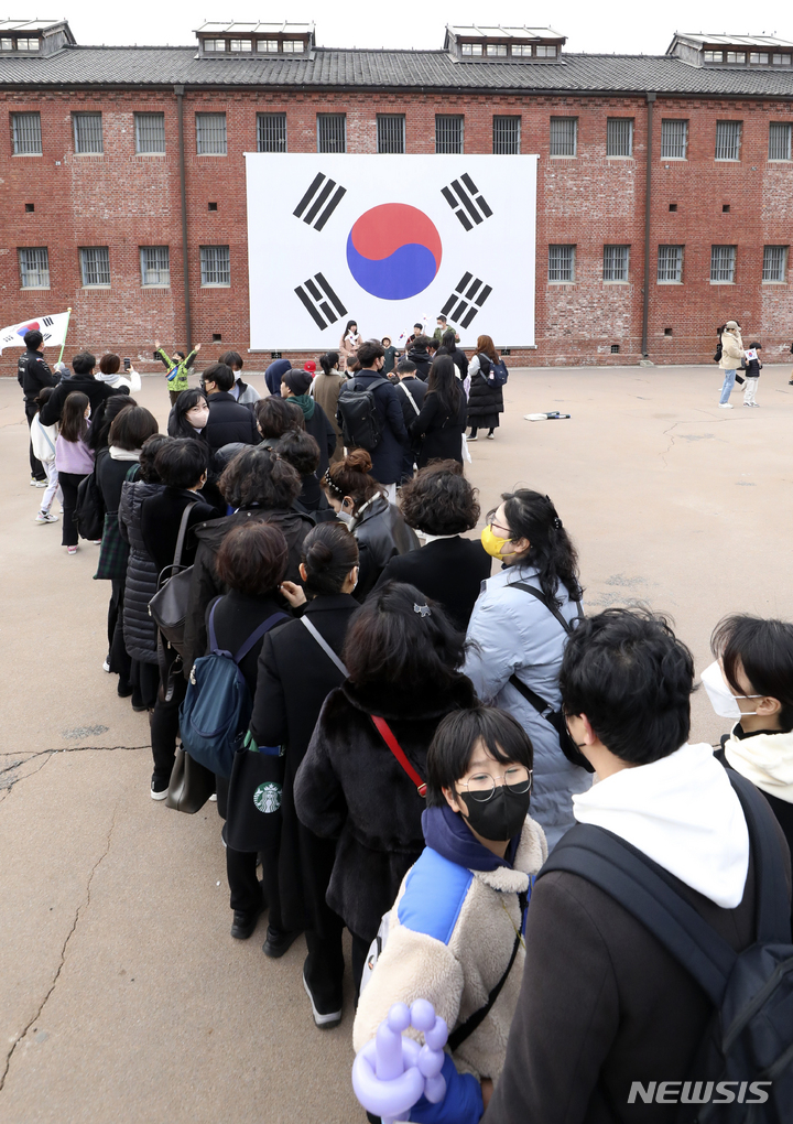 [서울=뉴시스] 최진석 기자 = 제104주년 3.1절인 1일 오전 서울 서대문형무소역사관에서 관람객들이 기념촬영을 위해 대형 태극기 앞에서 줄지어 대기하고 있다. 2023.03.01. myjs@newsis.com
