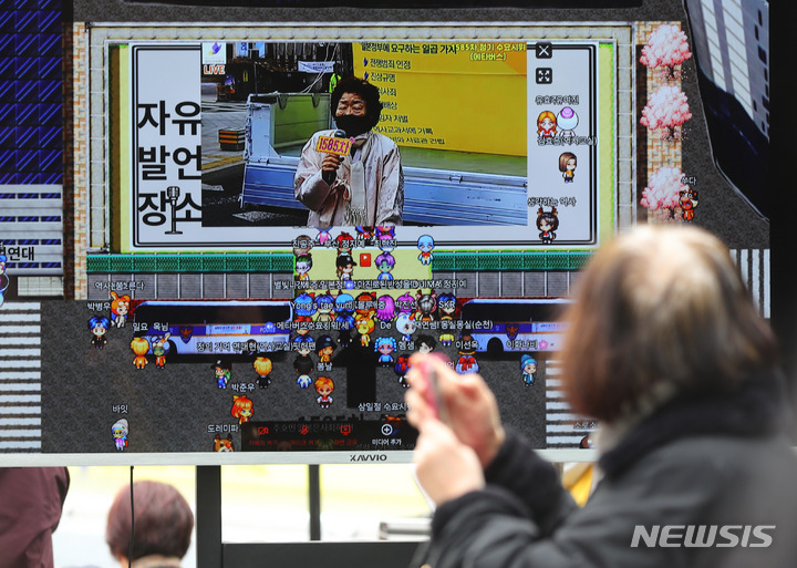 [서울=뉴시스] 배훈식 기자 = 제104주년 3.1절인 1일 오후 서울 종로구 일본대사관 인근에서 열린 1585차 일본군성노예제 문제해결을 위한 수요시위에 메타버스 참가자들이 표시된 모니터가 설치돼 있다. 2023.03.01. dahora83@newsis.com