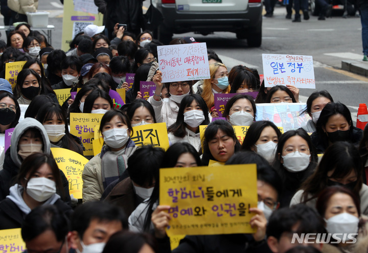 [서울=뉴시스] 배훈식 기자 = 제104주년 3.1절인 1일 오후 서울 종로구 일본대사관 인근에서 열린 1585차 일본군성노예제 문제해결을 위한 수요시위 참가자들이 일본의 사과와 배상을 촉구하는 손 피켓을 들고 있다. 2023.03.01. dahora83@newsis.com