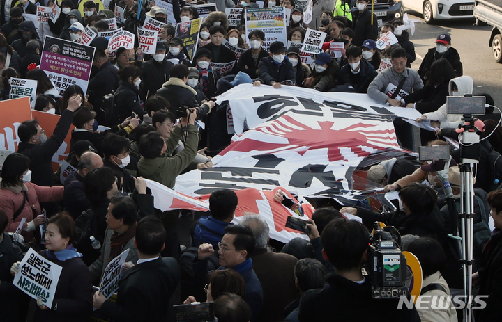 [서울=뉴시스] 고승민 기자 = 삼일절인 1일 서울광장에서 한일역사정의평화행동, 6.15남측위원회 주최로 열린 104주년 3.1절 범국민대회를 마친 참석자들이 일본대사관 앞으로 행진해 온 뒤 욱일기를 찢는 퍼포먼스를 하고 있다. 2023.03.01. kkssmm99@newsis.com