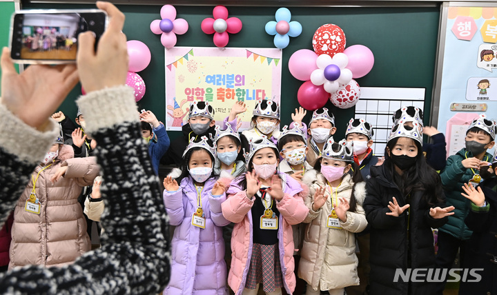 [수원=뉴시스] 김종택 기자 = 2일 오전 경기도 수원시 팔달구 매여울초등학교 1학년 교실에서 열린 입학식에서 왕관을 쓴 신입생들이 손을 흔들며 기념촬영을 하고 있다. 2023.03.02. jtk@newsis.com