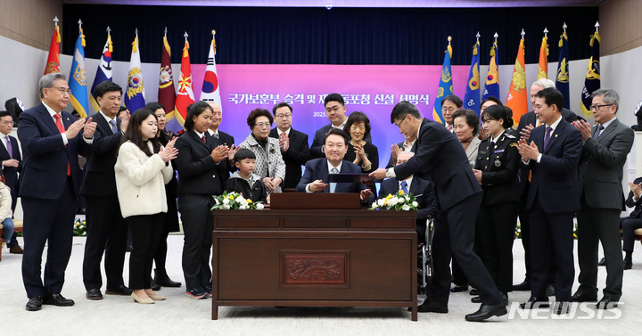 [서울=뉴시스] 홍효식 기자 = 윤석열 대통령이 2일 서울 용산 대통령실 청사에서 열린 국가보훈부 승격 및 재외동포청 신설 서명식에서 축하 메시지를 작성한 뒤 참석자들에게 박수 받고 있다. 2023.03.02. yesphoto@newsis.com