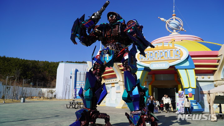 [창원=뉴시스] 홍정명 기자= 경남 마산로봇랜드 내 스카이타워와 미래로봇관 사이인 '정크로드'에 전시되어 있는 김후철 정크아티스트의 5m 높이 'G-robot' 정크아트.(사진=마산로봇랜드 제공) 2023.03.03. photo@newsis.com