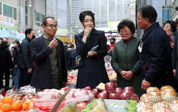 [포항=뉴시스] 홍효식 기자 = 윤석열 대통령 부인 김건희 여사가 3일 경북 포항 죽도시장을 방문해 지역 장애아동시설에 기부할 사과를 구입하기 위해 시식하고 있다. 2023.03.03. yesphoto@newsis.com
