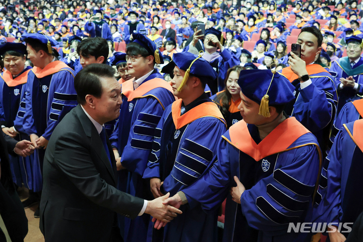 [서울=뉴시스] 윤석열 대통령이 27일 서울 서대문구 연세대학교에서 열린 2023년 2월 학위수여식에서 축사를 마친 뒤 졸업생들과 악수하고 있다. (사진=대통령실 제공) 2023.02.27. photo@newsis.com