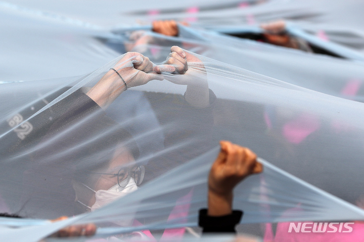 [서울=뉴시스] 백동현 기자 = 3.8 세계 여성의 날을 나흘 앞둔 4일 오후 서울 종로구 보신각 앞에서 전국여성노동조합 조합원들이 여성노동자 대회를 열고 유리천장을 찢는 퍼포먼스를 하고 있다. 사진은 기사 내용과 무관. 2023.03.04. livertrent@newsis.com