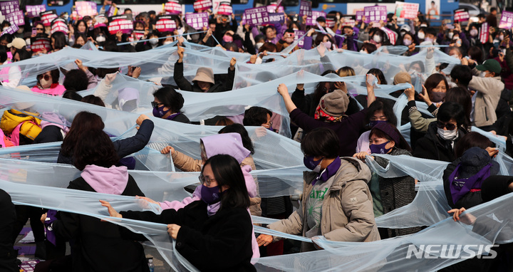 [서울=뉴시스] 백동현 기자 = 3.8 세계 여성의 날을 나흘 앞둔 4일 오후 서울 종로구 보신각 앞에서 전국여성노동조합 조합원들이 여성노동자 대회를 열고 유리천장을 찢는 퍼포먼스를 하고 있다. 2023.03.04. livertrent@newsis.com
