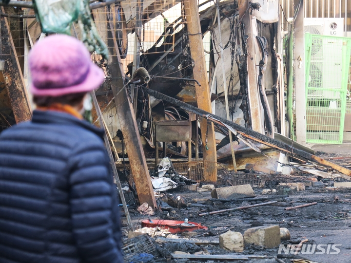 [인천=뉴시스] 김동영 기자 = 5일 오전 인천 동구 현대시장에서 한 상인이 불에 탄 점포를 바라보고 있다. 현대시장에서는 전날 화재가 발생해 시장 내부 212개 점포 가운데 55개 점포가 불에 탔다. 2023.03.05. dy0121@newsis.com 