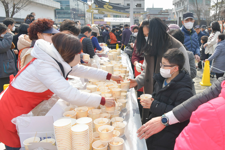 [뉴시스=공주]나눠주는 인절미를 받아든 초등학생.(사진=공주시) *재판매 및 DB 금지