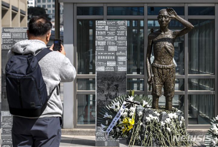 [서울=뉴시스] 정병혁 기자 = 6일 오후 서울 용산구 용산역광장에 세워진 강제징용노동자상 앞에서 한 시민이 사진을 찍고 있다. 정부는 이날 일제 강제징용 해법과 관련해 행정안전부 산하 '일제강제동원피해자지원재단'이 강제지용 피해자인 원고에 판결금 및 지연 이자를 지급할 것이라고 밝혔다. 재단의 재원은 민간의 자발적 기여 등을 통해 마련하기로 했다.  2023.03.06. jhope@newsis.com