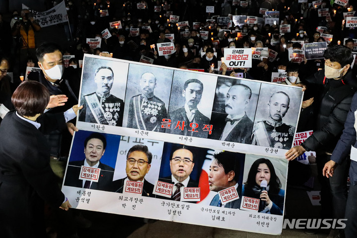 [서울=뉴시스] 권창회 기자 = 6일 오후 서울 중구 서울시청광장에서 열린 강제징용 피해배상에 대한 제3자 면제 방안 발표 규탄 촛불집회에서 박석운 전국민중행동 공동대표를 비롯한 참가자들이 '강제동원 계묘5적' 스티커를 붙이는 퍼포먼스를 하고 있다. 2023.03.06. kch0523@newsis.com