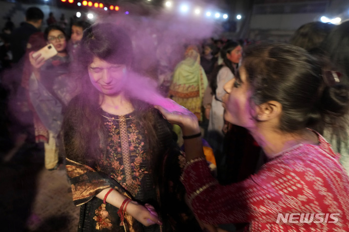 [카라치=AP/뉴시스] 6일(현지시간) 파키스탄 카라치에서 힌두교 공동체의 여성들이 홀리 축제를 맞아 얼굴에 색가루를 칠하고 있다. 전통 봄맞이 축제인 홀리 축제는 두세라, 디왈리와 함께 힌두교 3대 축제로 꼽힌다. 2023.03.07.