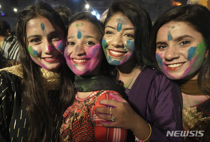 [카라치=AP/뉴시스] 6일(현지시간) 파키스탄 카라치에서 힌두교 공동체의 여성들이 홀리 축제를 맞아 얼굴에 색가루를 칠한 채 카메라를 향하고 있다. 전통 봄맞이 축제인 홀리 축제는 두세라, 디왈리와 함께 힌두교 3대 축제로 꼽힌다. 2023.03.07.