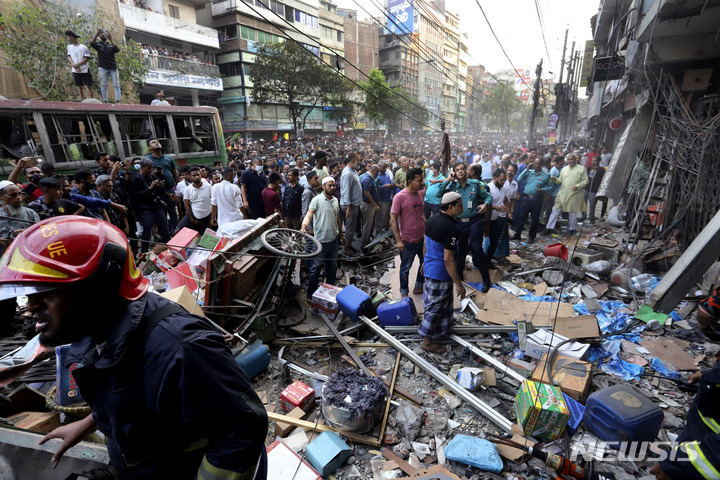 [다카=AP/뉴시스] 3월7일&nbsp; 방글라데시 다카의 건물 폭발 현장에 구경꾼들이 모여 있다. 소방 당국은 7층짜리 상가 건물이 폭발해 최소 18명이 숨지고 120여 명이 다쳤다고 밝혔다. 현지 경찰국장은 "이번 폭발을 사고로 보고 있으며 테러 행위는 아닌 것으로 보인다"라고 밝혔다. 2023.03.08.