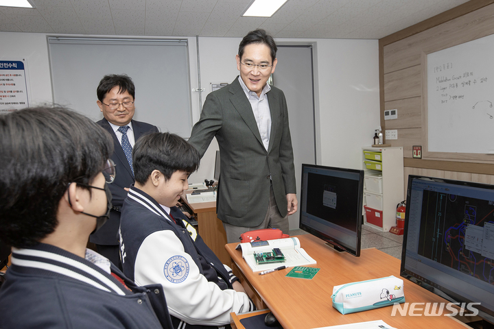 [서울=뉴시스]이재용 삼성전자 회장이 7일 경북 구미시에 위치한 구미전자공업고등학교를 방문해 수업을 참관하고 학생들과 기념사진을 촬영하는 모습. (사진=삼성전자 제공) photo@newsis.com