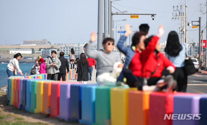 [제주=뉴시스] 우장호 기자 = 제주시 무지개해안도로를 찾은 관광객들이 가벼운 옷차림으로 기념촬영을 하며 즐거운 시간을 보내고 있다. (사진=뉴시스DB) woo1223@newsis.com