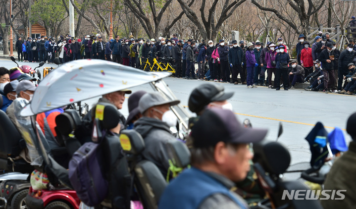 [대구=뉴시스] 이무열 기자 = 코로나19 이후 3년간 중단됐던 대한적십자사 대구지사 이동 무료 급식이 재개된 8일 오전 대구 달서구 두류공원에서 어르신들이 점심 배식을 받기 위해 줄을 서고 있다. 2023.03.08. lmy@newsis.com