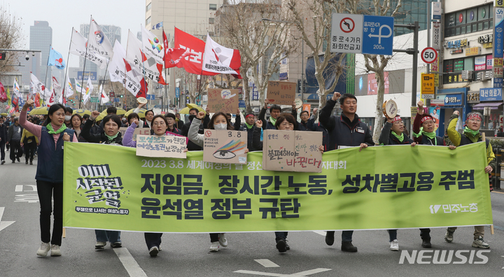 [서울=뉴시스] 김금보 기자 = 전국민주노동조합총연맹 조합원들이 8일 오후 서울 종로구 보신각 앞에서 '세계여성의 날 정신계승 전국노동자대회' 사전대회를 열고 본대회가 열리는 마로니에공원까지 행진을 하고있다. 2023.03.08. kgb@newsis.com