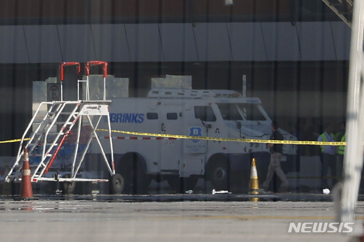 [산티아고(칠레)= AP/뉴시스] 칠레 수두의 아르투로 메리노 베니테스국제공항에서 3월 8일 (현지시간)  3200만 달러가 넘는 거액의 달러를 환적하다 강도들의 습격을 당한 현금수송차가 경찰의 금지선 안에 정차되어 있다. 