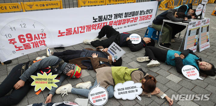 [서울=뉴시스] 조수정 기자 = 민주노총이 지난 9일 서울 용산구 대통령집무실 앞에서 '노동시간 개악 저지 윤석열 정부 규탄' 기자회견을 열고 과로사 퍼포먼스를 하고 있다. 민주노총은 근로시간제도 개편방안과 관련 "한주 근로시간을 69시간으로 늘리면 사용자가 5일 연속 아침 9시부터 자정까지 일을 시켜도 문제되지 않는다"며 "사용자와 부자들을 위해 노동자의 일방적 희생을 전제로 하는 개악이며 '과로사 조장법'에 불과하다"며 즉각 폐기를 촉구했다. 2023.03.09.chocrystal@newsis.com