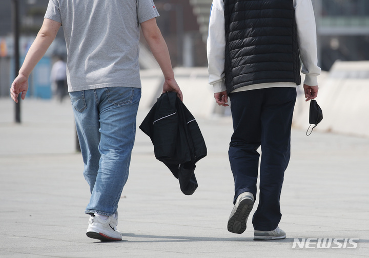 [서울=뉴시스] 서울 여의도 한강공원에서 한 시민이 외투를 손에 들고 걷고 있는 모습. (사진=뉴시스DB) photo@newsis.com