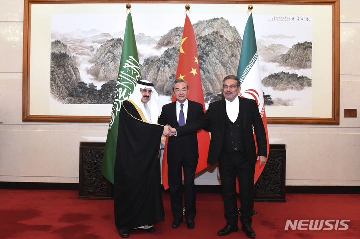 [베이징=AP/뉴시스]이란 최고 지도자인 아야톨라 알리 하메네이의 측근인 알리 샴카니 최고국가안보회의(NSC) 의장이 16일 아랍에미리트(UAE)를 방문한다. 사진은 지난 11일 중국 베이징에서 무사드 빈 무함마드 알아이반 사우디이라비아 국가안보 보좌관(왼쪽)이 왕이 중국 공산당 중앙정치국 위원을 가운데 두고 샴카니 의장(오른쪽)과 악수하는 모습. 2023.03.16