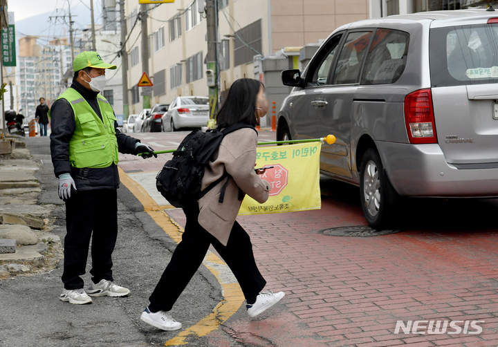 [광주=뉴시스] 김혜인 기자 = 9일 오전 광주 남구 봉선동 한 초등학교 어린이보호구역에서 학생이 길을 건너고 있다.  2023.03.09. hyein0342@newsis.com