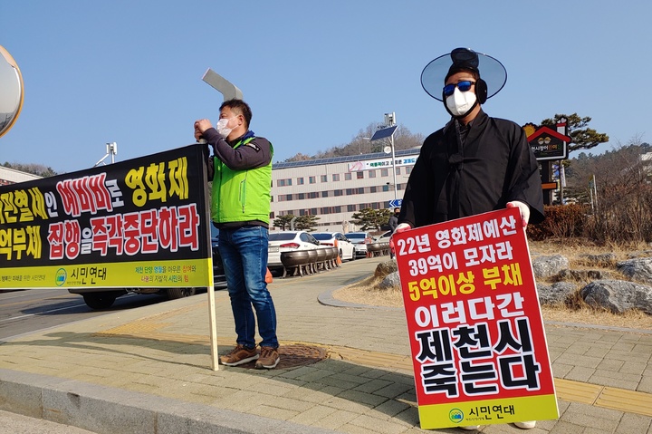 제천단양영월 시민연대 회원들이 충북 제천시청 앞에서 '제천국제음악영화제' 결손금 예비비 충당에 반발하며 영화제 폐지 등을 요구하는 퍼포먼스를 하고 있다. 2023.3.12. nulha@newsis.com *재판매 및 DB 금지